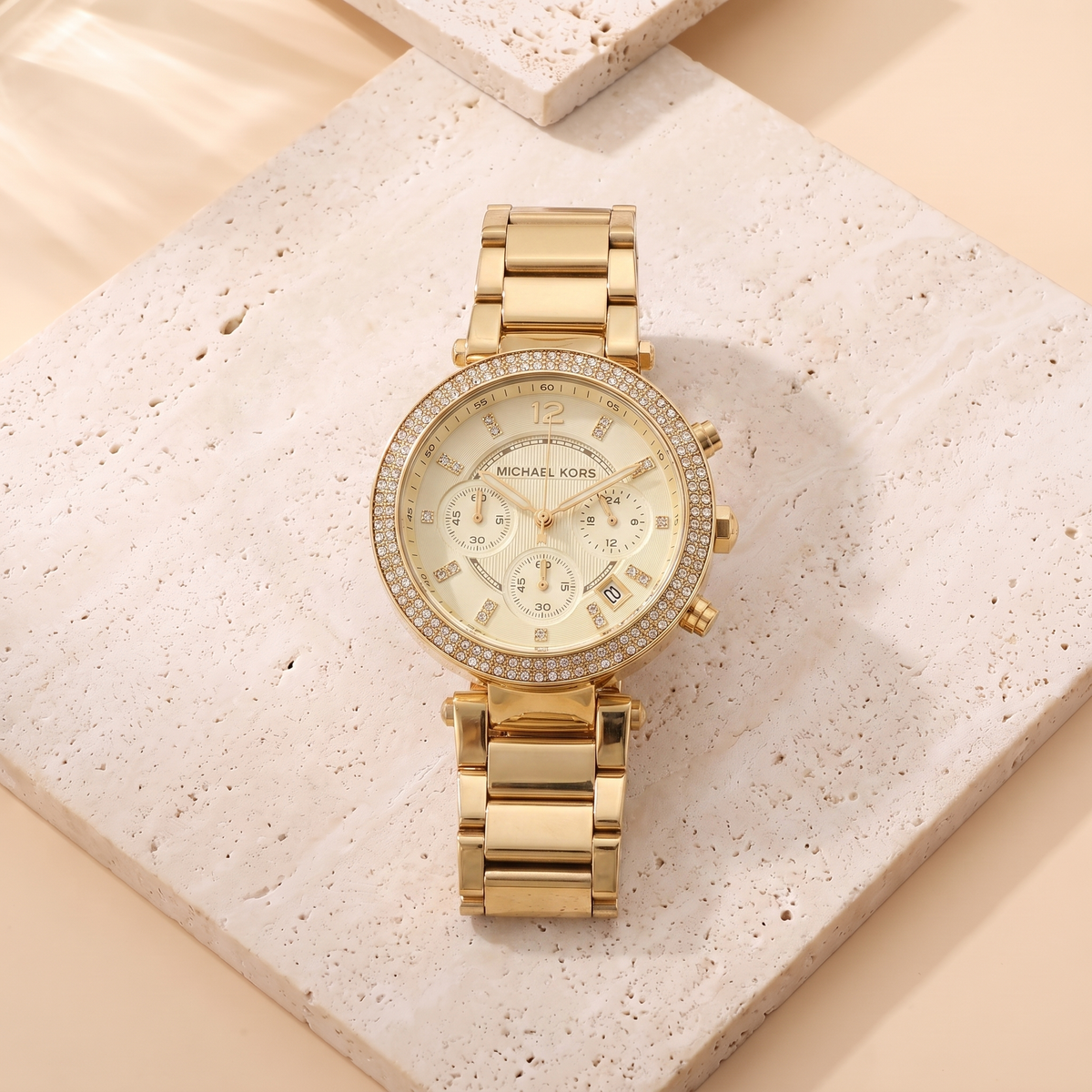 Montre Michael Kors Parker Gold, fond travertin