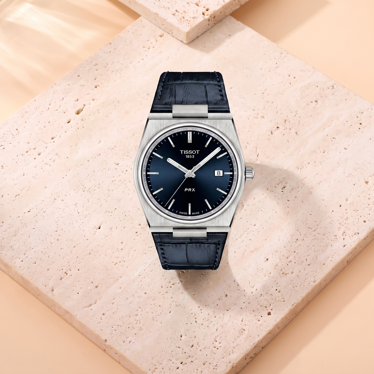 Montre Tissot PRX Leather, fond travertin