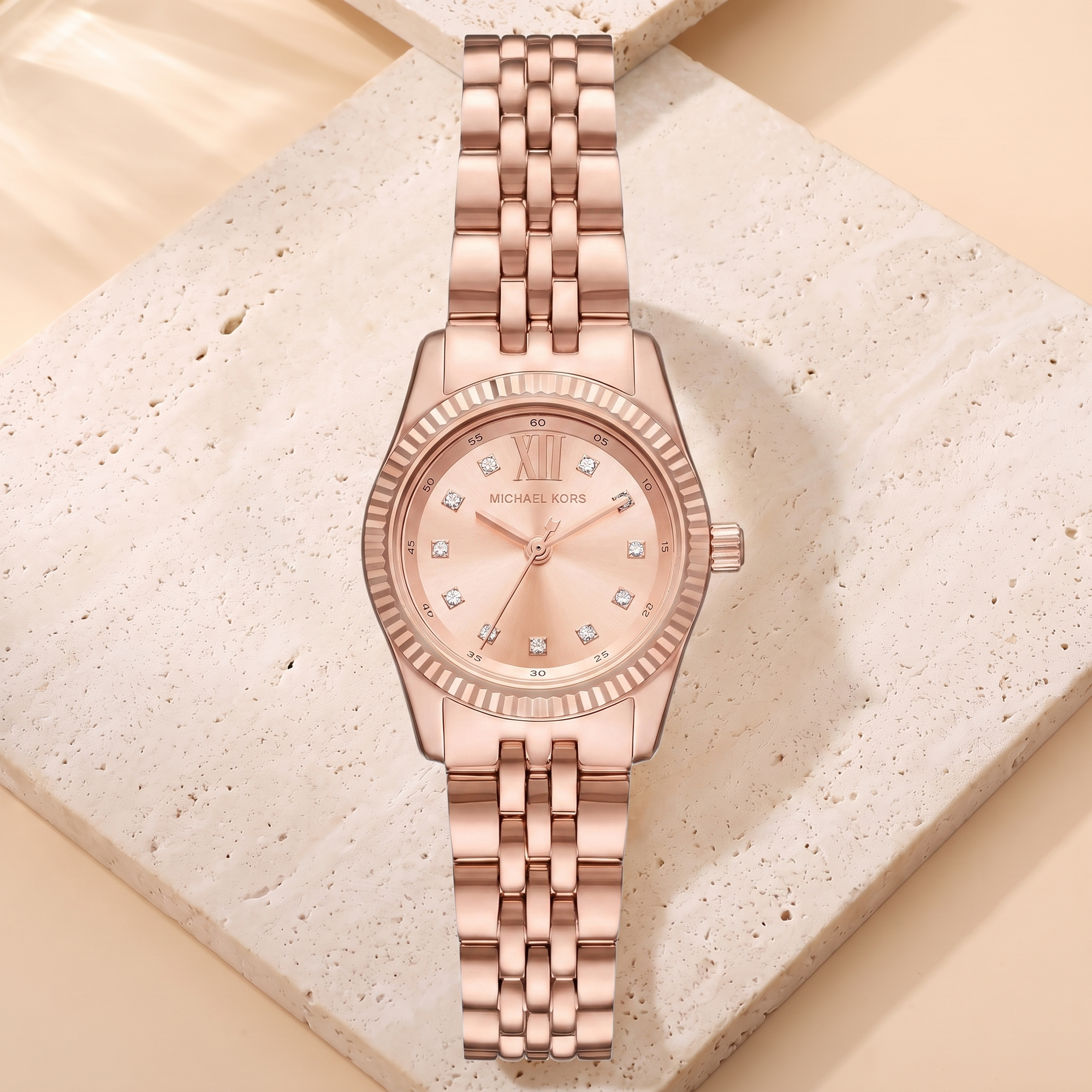 Montre Michael Kors Petite Lexington Rosegold, fond travertin