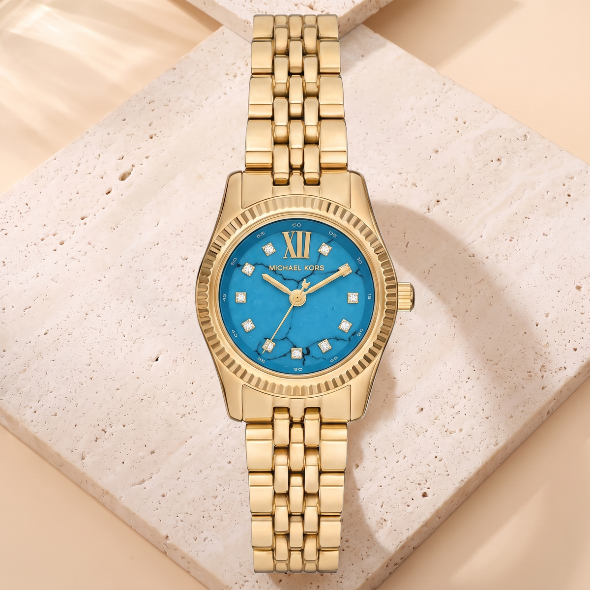 Montre Michael Kors Petite Lexington Bleu Tiffany, fond travertin